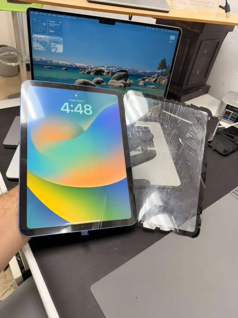 Close-up of an iPad with a cracked glass screen on a clean background