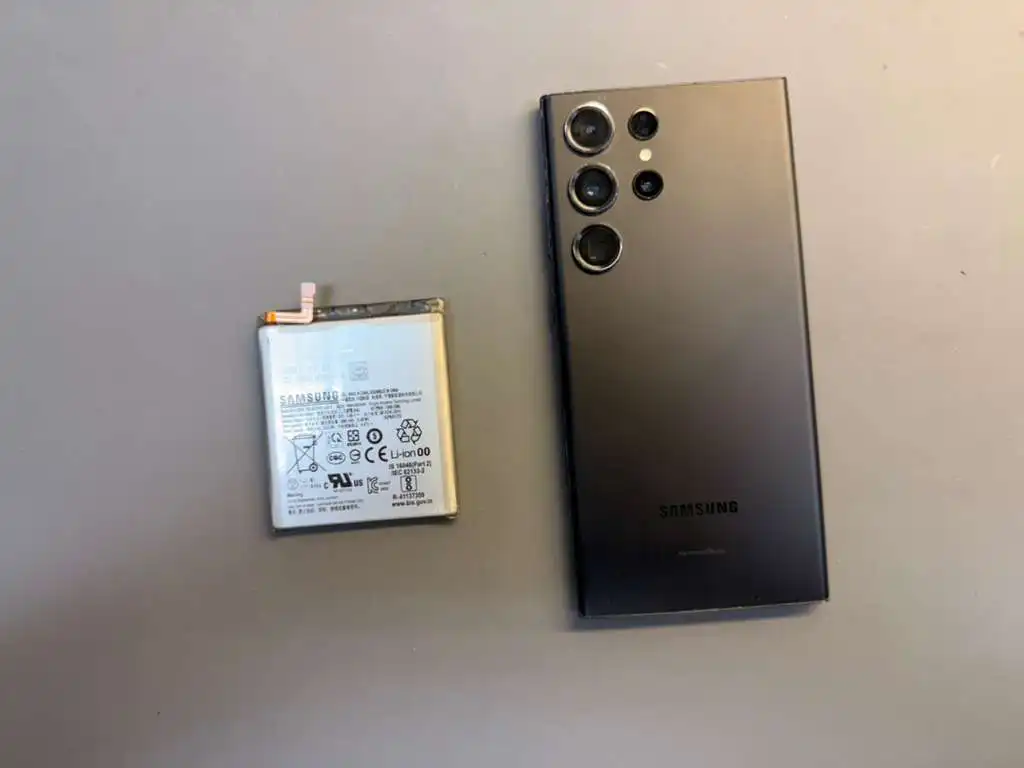 Samsung phone battery replacement in progress on a repair bench